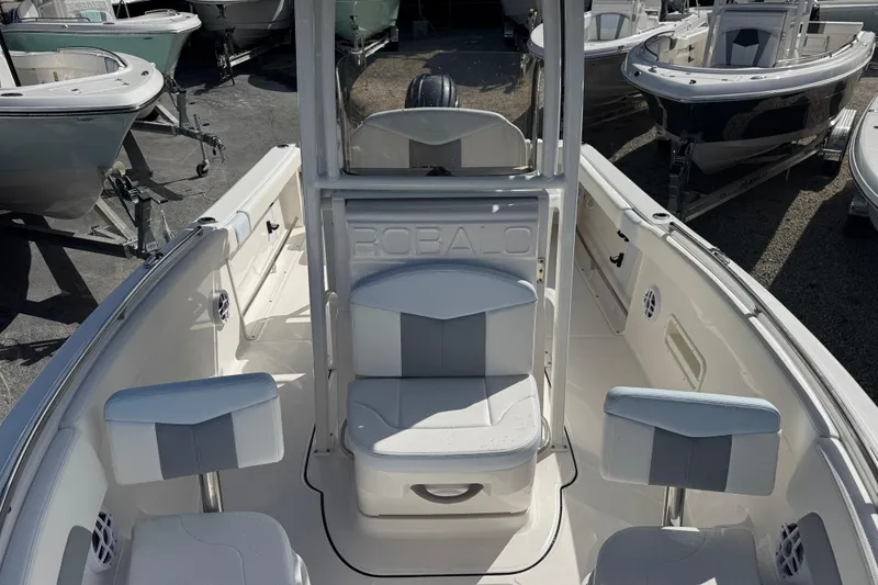 Slide: The Image of 2025 Robalo R222 Explorer boat interior with seating and console, displayed outdoors. - 11