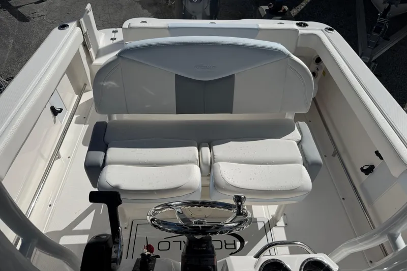 Slide: The Image of 2025 Robalo R222 Explorer boat interior with white seating and steering wheel. - 16