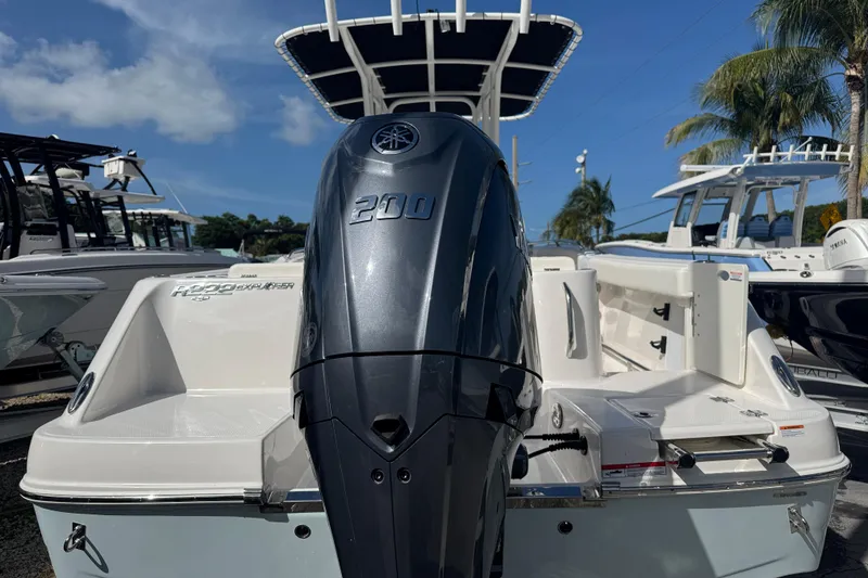 Slide: The Image of 2025 Robalo R222 Explorer boat with powerful 200 HP engine, docked under clear skies. - 2