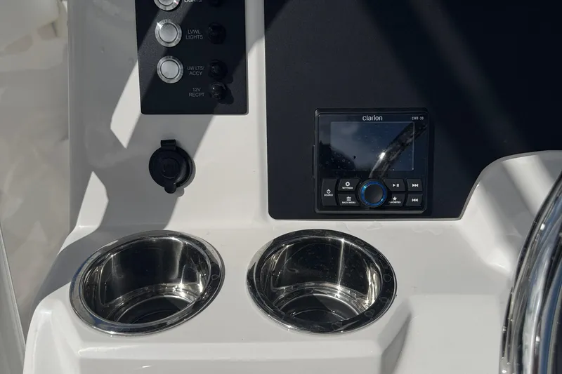 Slide: The Image of 2025 Robalo R222 Explorer dashboard with controls, Clarion audio system, and dual cup holders. - 22