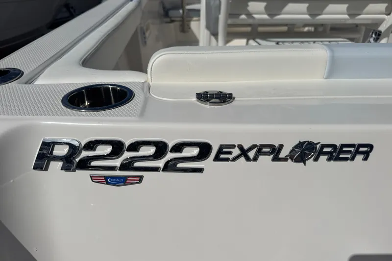 Slide: The Image of 2025 Robalo R222 Explorer boat logo on white surface with cup holders. - 3