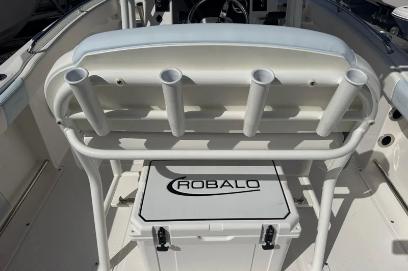 Slide: The Image of 2025 Robalo R222 Explorer boat interior with rod holders and branded cooler. - 6
