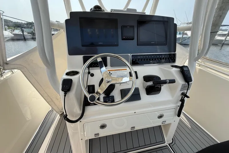 Slide: The Image of 2019 Cobia 277 Center Console boat helm with dual screens and steering wheel. - 10