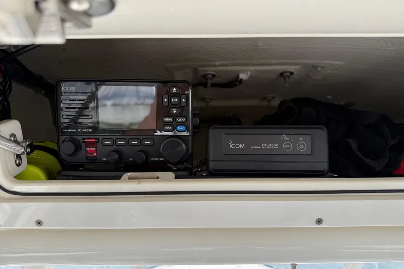 Slide: The Image of ICOM marine radio equipment inside a 2019 Cobia 277 Center Console boat compartment. - 12