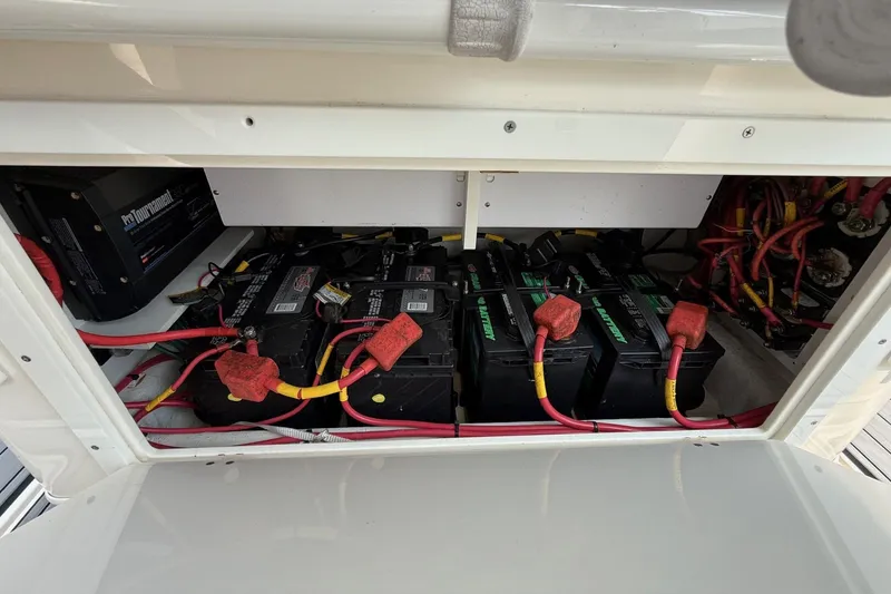 Slide: The Image of 2019 Cobia 277 Center Console battery compartment with multiple batteries and wiring. - 18