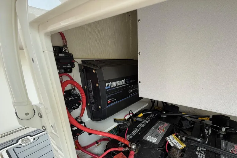 Slide: The Image of 2019 Cobia 277 Center Console boat battery compartment with ProTournament 360 charger and wiring. - 19