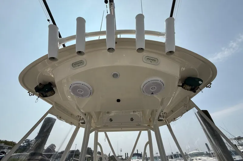 Slide: The Image of 2019 Cobia 277 Center Console boat, view of the overhead console with speakers and rod holders. - 20