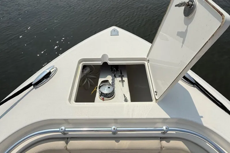 Slide: The Image of 2019 Cobia 277 Center Console anchor locker open on calm water. - 28