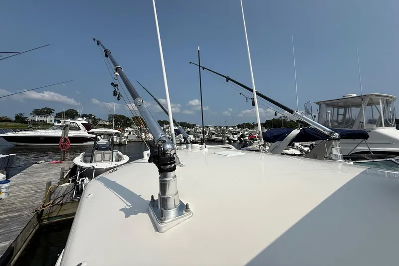 Slide: The Image of 2019 Cobia 277 Center Console boat docked with fishing rods, clear sky background. - 33