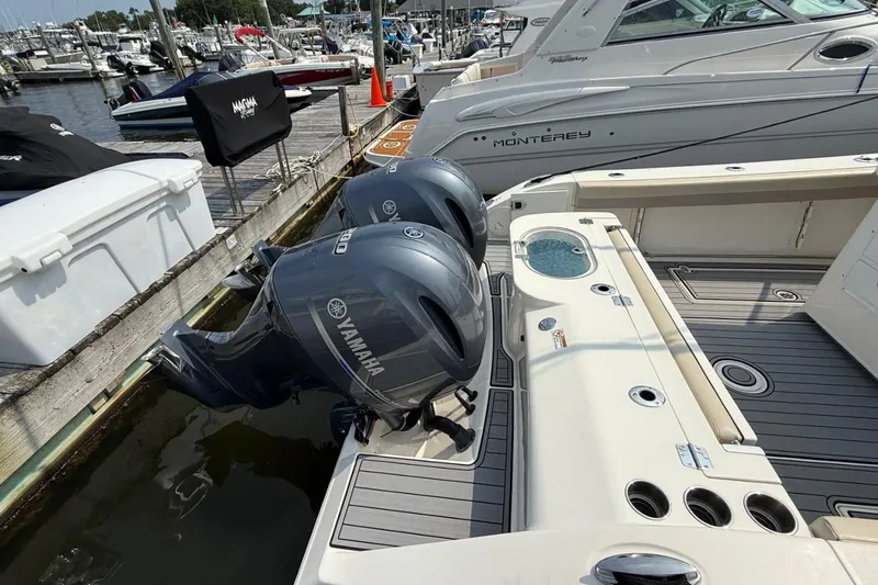 Slide: The Image of 2019 Cobia 277 Center Console with twin Yamaha outboard engines at marina dock. - 8