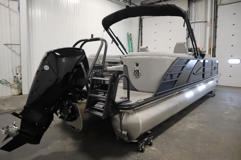 Slide: The Image of 2025 Bentley Pontoons Elite 253 Admiral Tri-toon in a garage, featuring a Mercury outboard motor. - 4