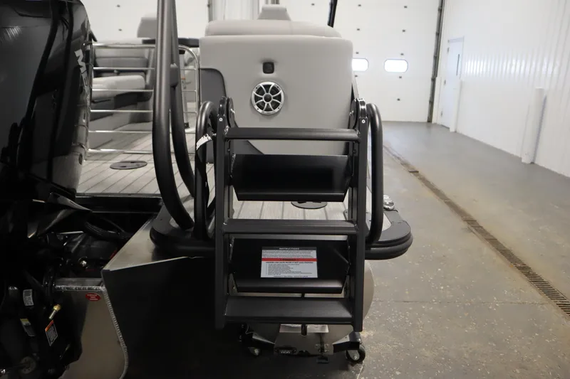 Slide: The Image of 2025 Bentley Pontoons Elite 253 Admiral Tri-toon rear view with boarding ladder in a garage. - 45