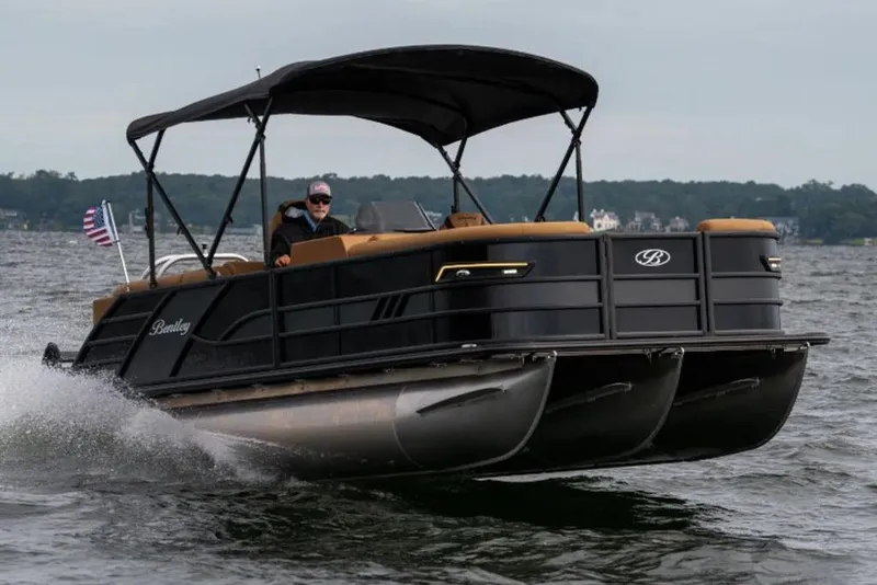 Slide: The Image of 2025 Bentley Pontoons Elite 253 Admiral Tri-toon cruising on a lake with American flag. - 52