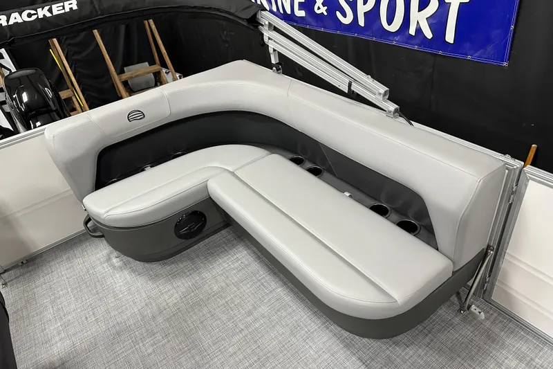 Slide: The Image of 2026 Sun Tracker Party Barge 16 DLX seating area with gray upholstery and cup holders. - 12