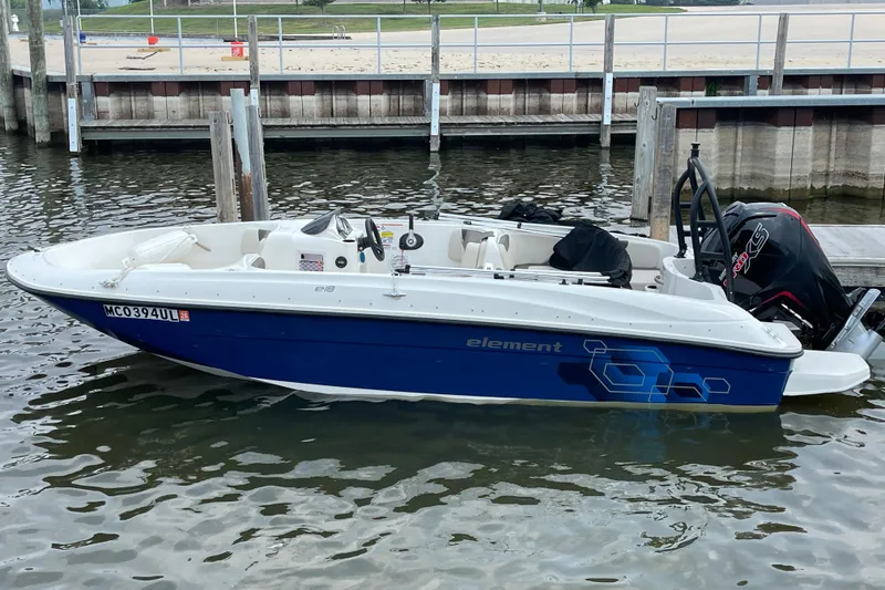 The Image of 2020 Bayliner Element boat docked in a marina, featuring a sleek blue and white design. - 1