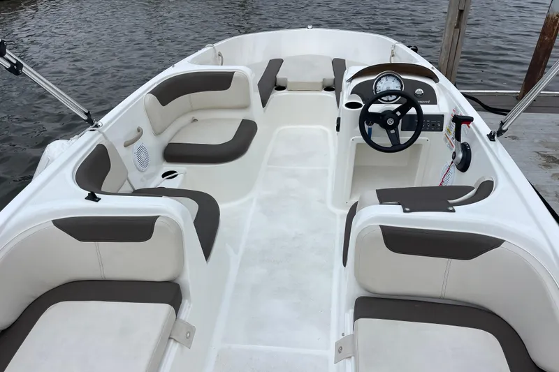 Slide: The Image of 2020 Bayliner Element boat interior with seating and steering wheel, docked by the water. - 10