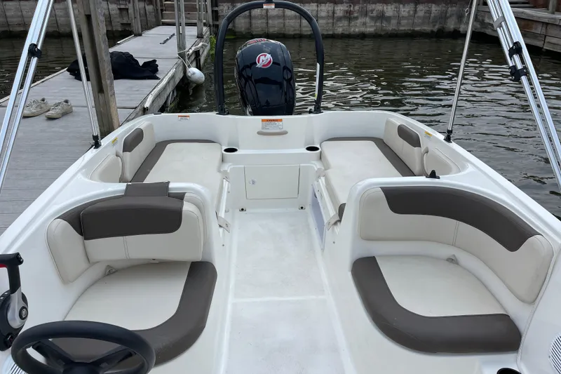 Slide: The Image of 2020 Bayliner Element boat interior with seating, docked by the water. - 12