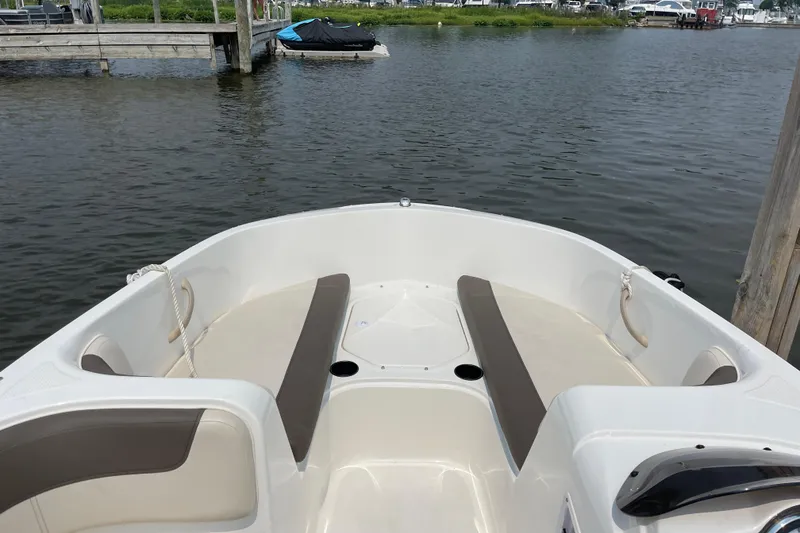 Slide: The Image of 2020 Bayliner Element boat interior with seating, docked by calm waters. - 17