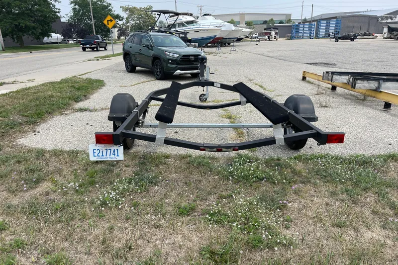 Slide: The Image of Trailer for 2020 Bayliner Element boat parked on grass near road and vehicles. - 20