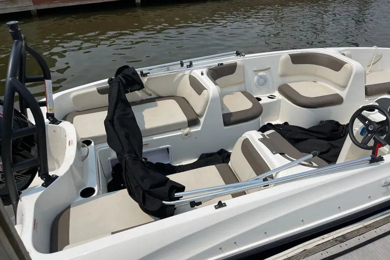 Slide: The Image of 2020 Bayliner Element boat interior with beige seating, docked by the water. - 5