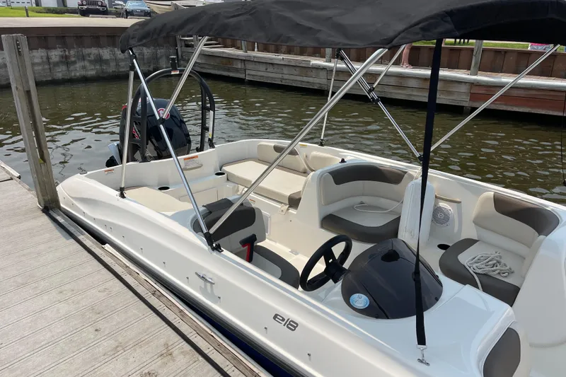 Slide: The Image of 2020 Bayliner Element boat docked, featuring seating and canopy. - 6