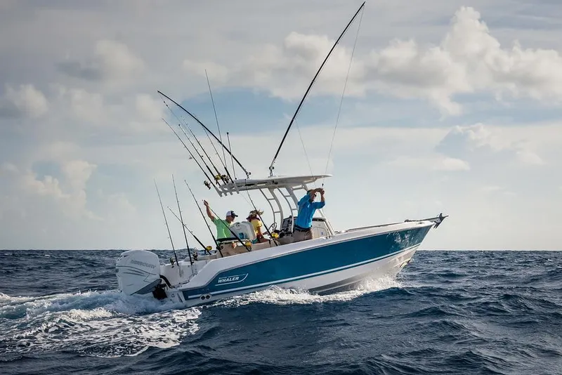 Slide: The Image of 2026 Boston Whaler 230 Outrage boat with dual engines, parked outdoors. - 1