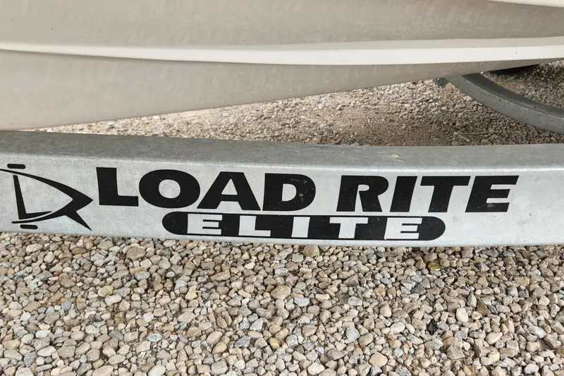 Slide: The Image of Load Rite Elite trailer for 2022 Walker Bay Generation 525 DLX on gravel surface. - 4