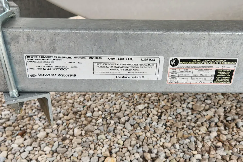 Slide: The Image of Trailer label with specifications and tire information, Load Rite Trailers, 2021, on gravel surface. - 5