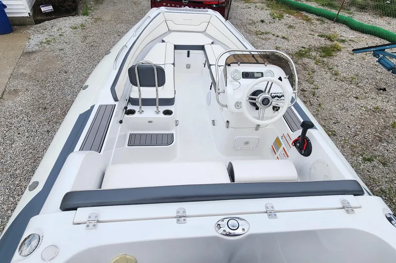 Slide: The Image of 2022 Walker Bay Generation 525 DLX boat interior with steering console and seating. - 7