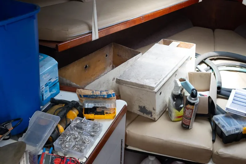 Slide: The Image of Interior of 1978 Bertram 35 Flybridge Sportfish with tools and supplies scattered. - 15