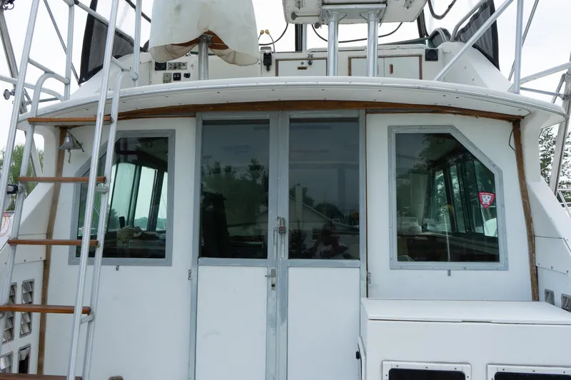 Slide: The Image of 1978 Bertram 35 Flybridge Sportfish boat rear view with ladder and windows. - 2