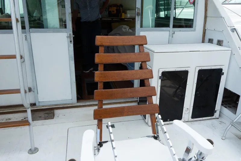 Slide: The Image of 1978 Bertram 35 Flybridge Sportfish deck with wooden chair and cabin entrance. - 20