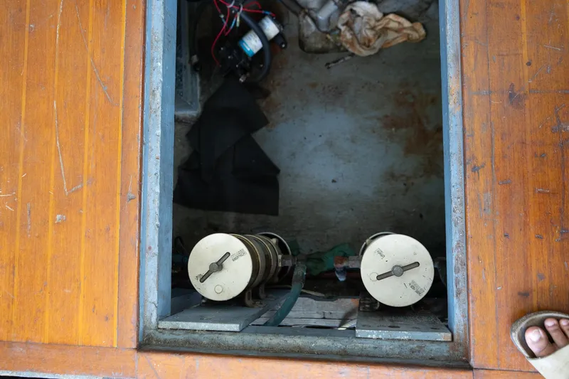 Slide: The Image of 1978 Bertram 35 Flybridge Sportfish engine compartment with wooden deck and mechanical components. - 27