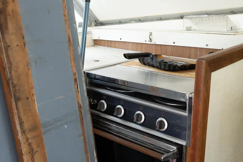 Slide: The Image of 1978 Bertram 35 Flybridge Sportfish interior kitchen with stove and cutting board. - 29