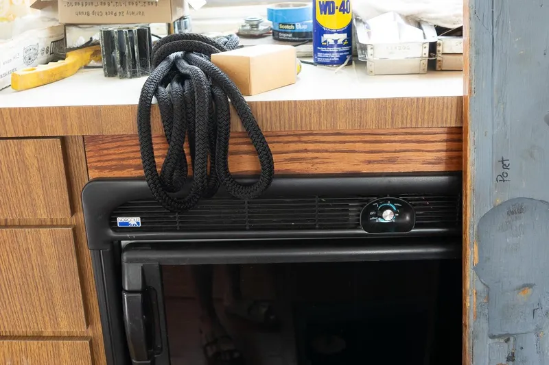 Slide: The Image of 1978 Bertram 35 Flybridge Sportfish interior with rope, tools, and WD-40 on counter. - 30