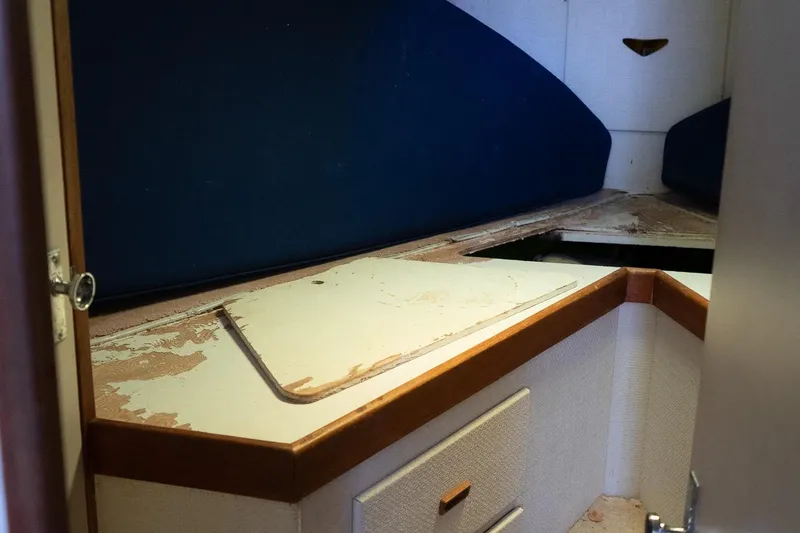 Slide: The Image of 1978 Bertram 35 Flybridge Sportfish cabin interior with blue cushions and storage space. - 33