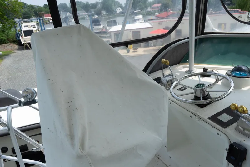 Slide: The Image of 1978 Bertram 35 Flybridge Sportfish helm with covered seat and steering wheel. - 38
