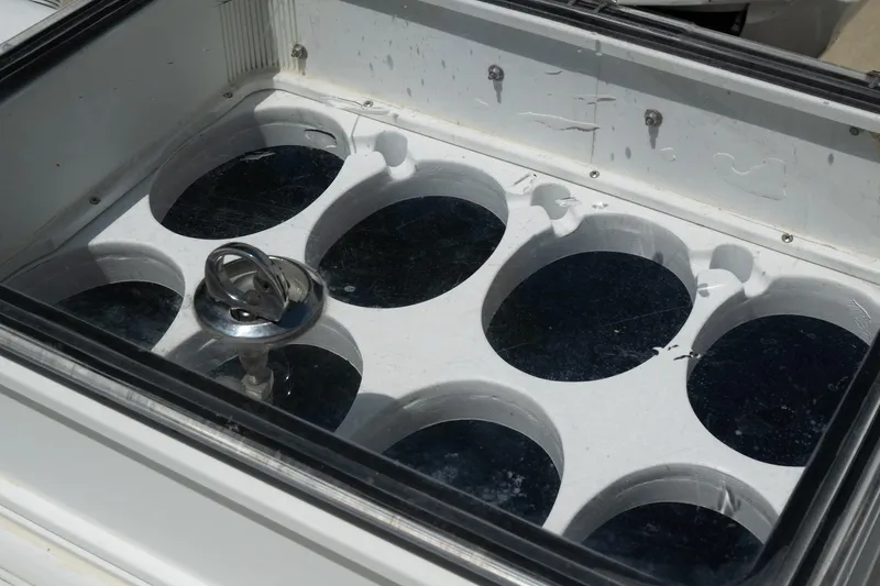 Slide: The Image of Storage compartment on 2023 Contender 44 ST boat, featuring circular slots and a metal fixture. - 11