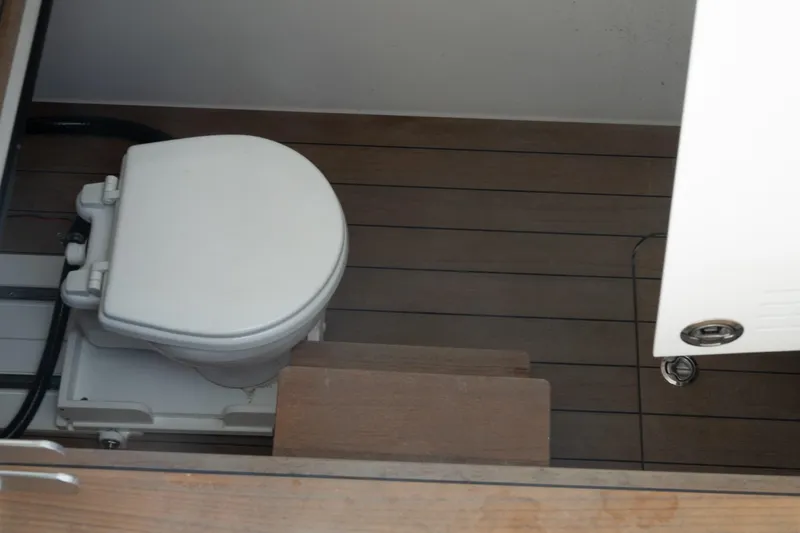 Slide: The Image of 2023 Contender 44 ST boat bathroom with wooden flooring and compact toilet. - 13