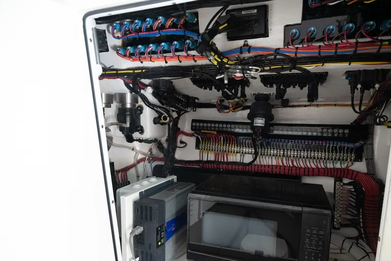 Slide: The Image of Electrical panel inside 2023 Contender 44 ST boat, showcasing wiring and components. - 8