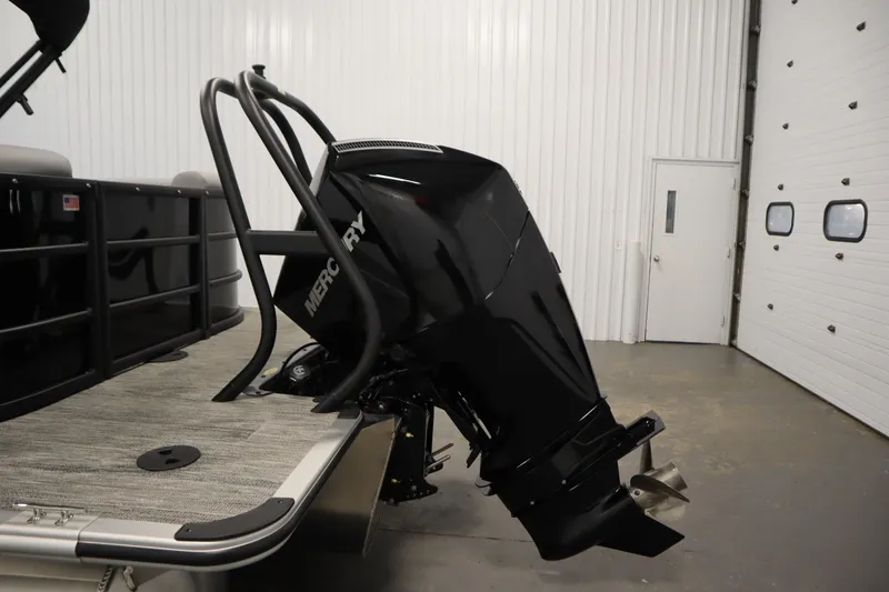 Slide: The Image of 2025 Bentley Pontoons Legacy 243 DL Navigator Tri-toon with Mercury outboard motor in a garage. - 35
