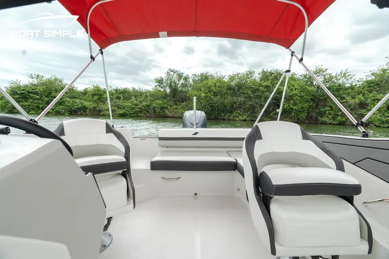 Slide: The Image of 2024 Starcraft SVX 190 OB DC boat interior with red canopy and seating. - 8