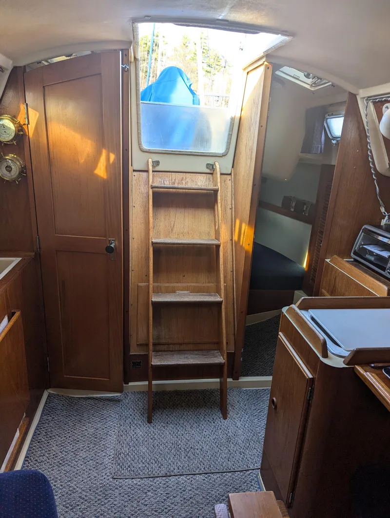 Slide: The Image of Interior of a 1985 Pearson P-28 sailboat with wooden ladder and cozy cabin space. - 13