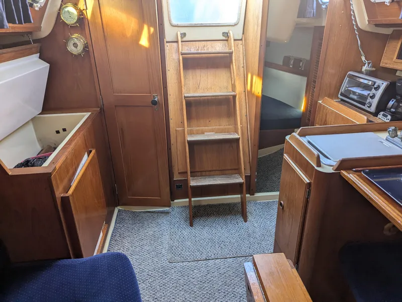Slide: The Image of Interior of 1985 Pearson P-28 sailboat with wooden cabinetry and compact kitchen area. - 14