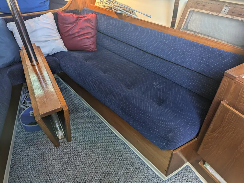 Slide: The Image of Interior of 1985 Pearson P-28 sailboat with blue cushioned seating and wooden accents. - 17