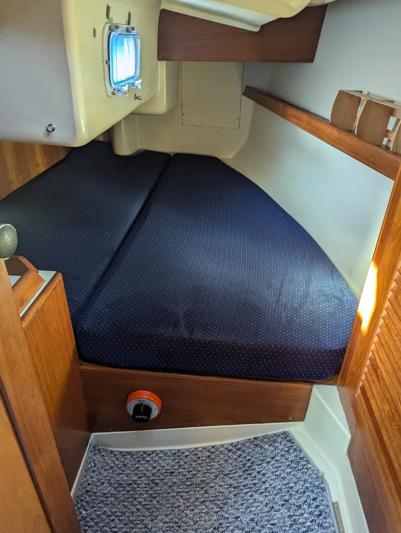 Slide: The Image of 1985 Pearson P-28 sailboat cabin with cozy bed and wooden interior. - 20
