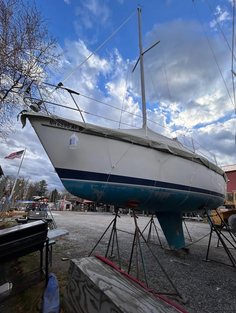 Slide: The Image of 1985 Pearson P-28 sailboat on stands under a cloudy sky. - 3