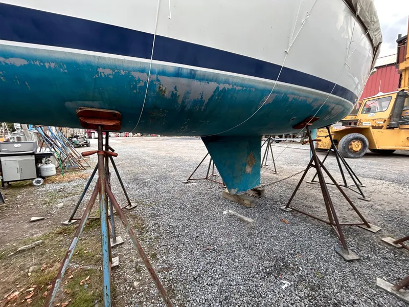 Slide: The Image of 1985 Pearson P-28 sailboat hull on stands in a boatyard. - 6