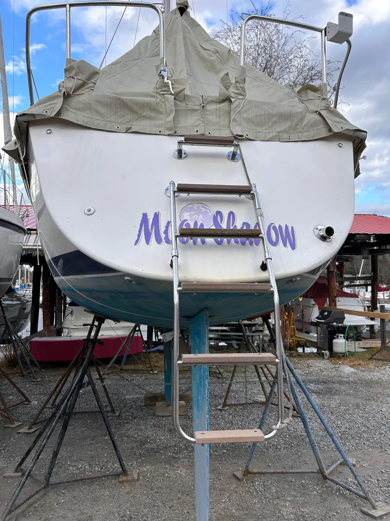 Slide: The Image of 1985 Pearson P-28 sailboat named "Moon Shadow" on stands, covered and docked. - 8