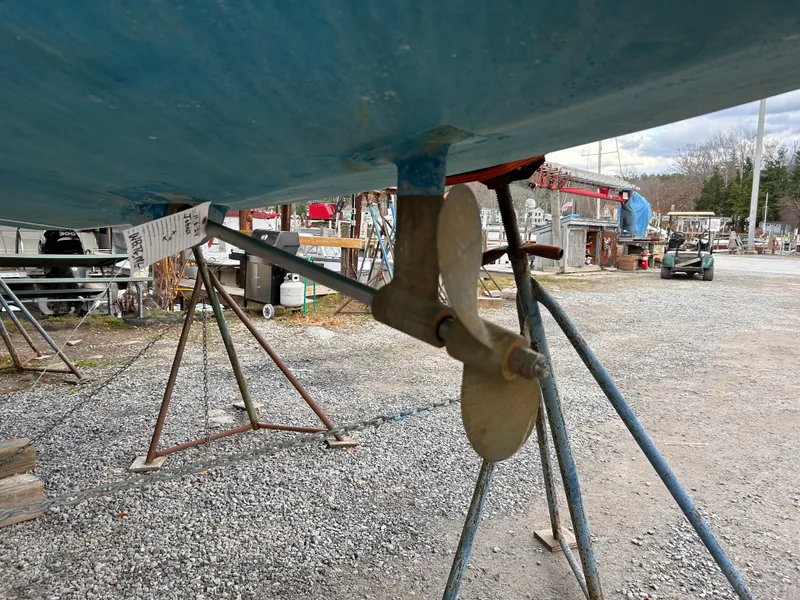Slide: The Image of Pearson P-28 sailboat propeller and rudder, 1985 model, on a gravel boatyard. - 9